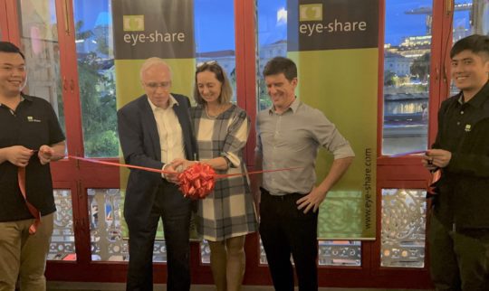 CEO of Eye-share (Torhill Falnes) and Norways ambassador to Singapore are cutting a red ribbon smiling