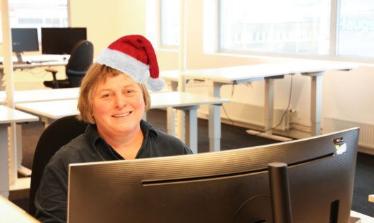 Department manager Solution Services, Siw Gjerdingen, sitting in front of a computer with a christmas hat