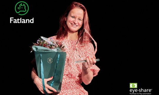 Woman smiling with a prize and a bouquet of flowers in her arms. The logo of Fatland and Eye-share is on the picture