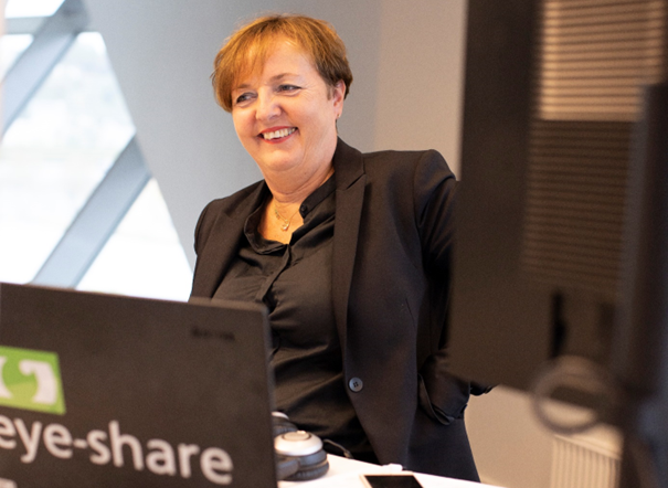 Smiling Eye-share employee (Liv Gilje-Sørnes) sitting in front of a computer