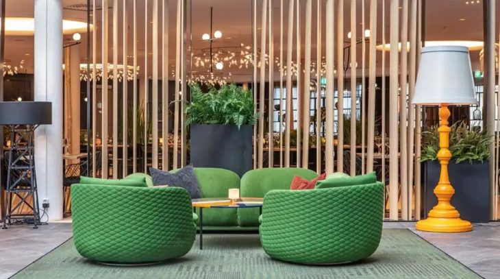 Quality Hotel Airport Gardermoen hotel lobby with green chairs, yellow lamp and wooden wall details