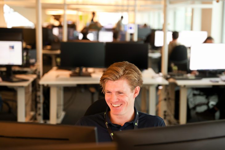 William Skaar, Technical Consultant in front of computer smiling.