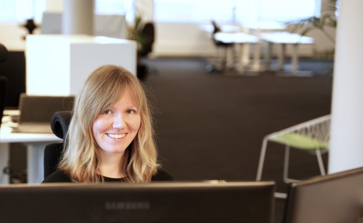 Software tester, Ellen Nymark, smiling in front of computer