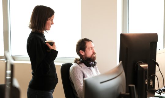 Eye-share employees in office landscape in front of computer.