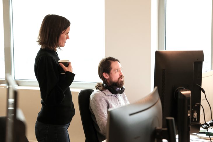 Eye-share employees in office landscape in front of computer.