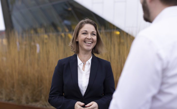 Dina Drehn, Director of Dep. Oslo smiling outside office building.