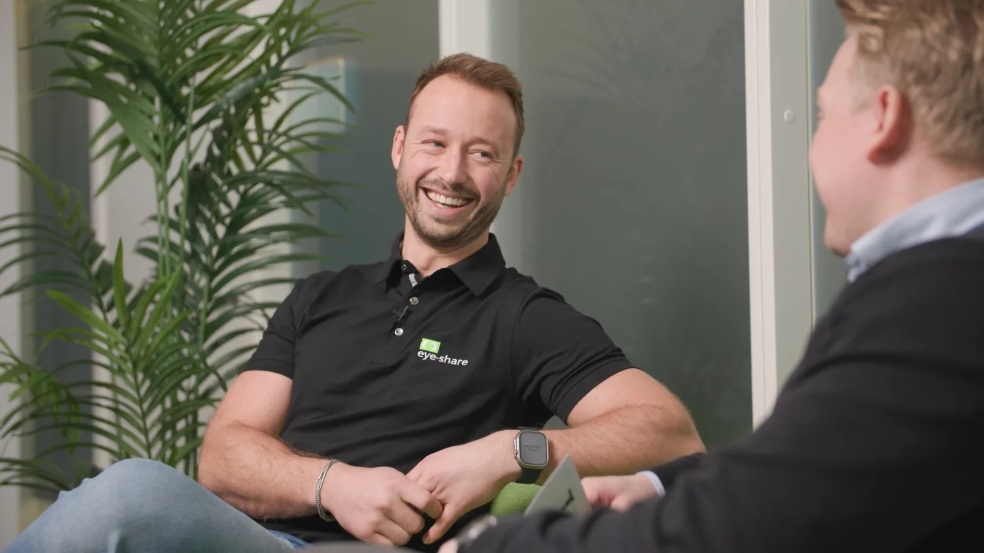 Advisor, Eimund Aase, sitting in green couch smiling.