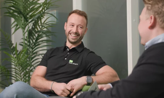 Advisor, Eimund Aase, sitting in green couch smiling.