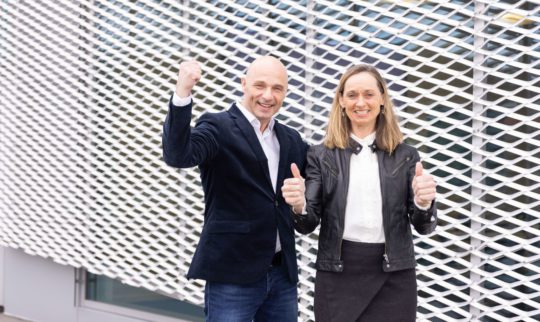 Director of Partners and International offices and CEO Torhill Falnes cheering outside an office building.