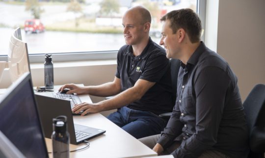 Eye-share employees working in front of computer in office premises smiling